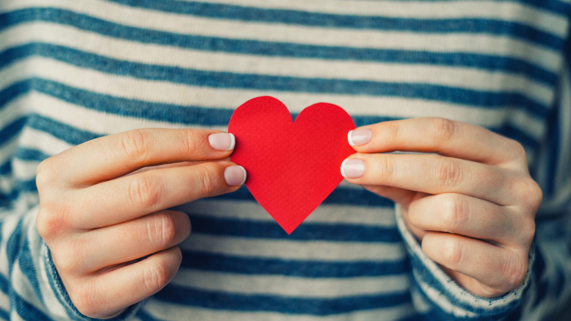 Woman holding red paper heart